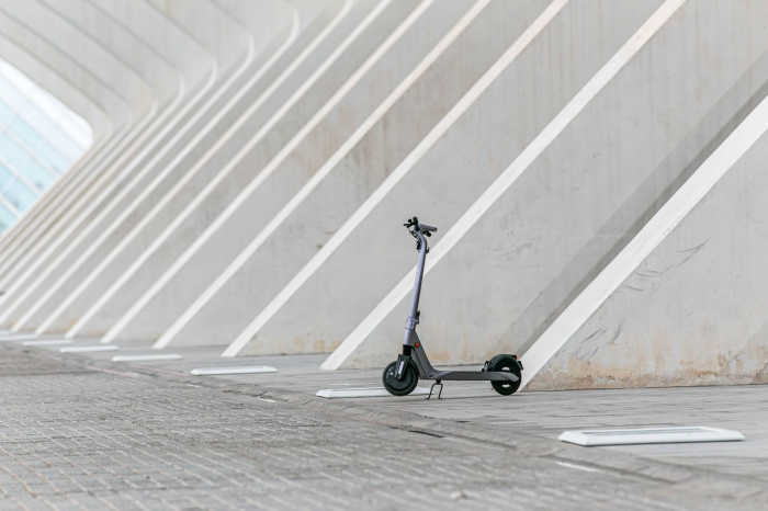 An electric scooter with its brake down under an archway.
