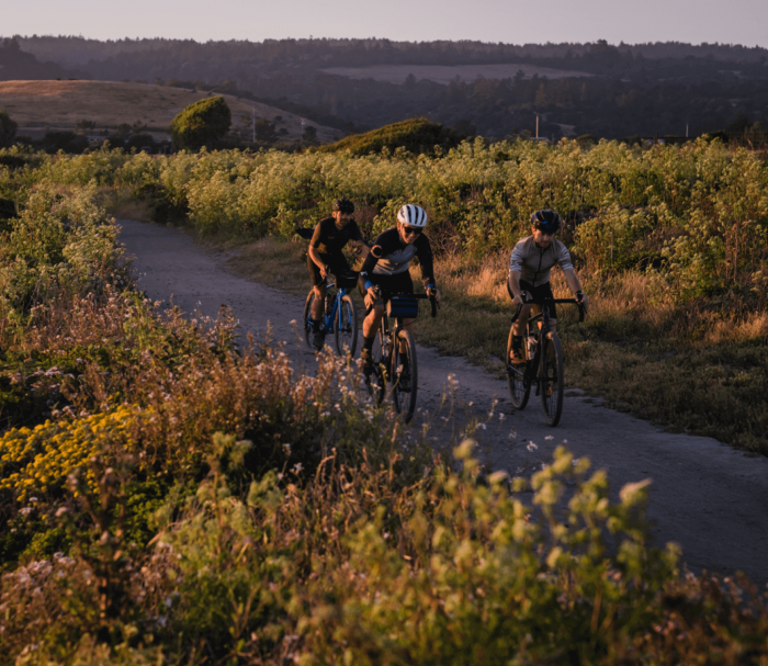 A trio riding Cannondale Topstone bikes through a country path.